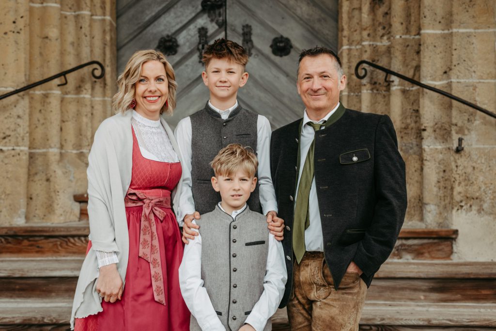 Familie in traditioneller Tracht vor steinernem Gebäude