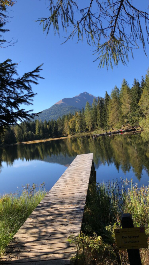 Holzsteg am Schattensee mit Bergpanorama und Spiegelung im Wasser